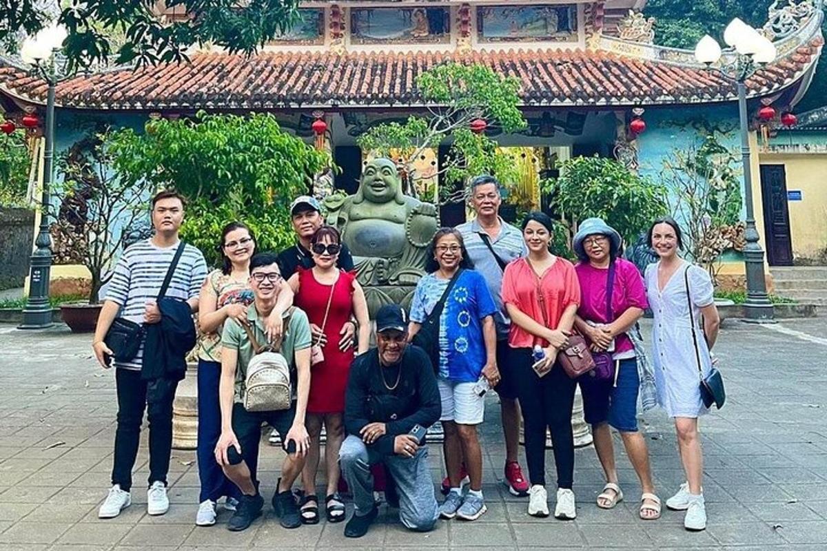 a group of people posing for a picture in front of a statue