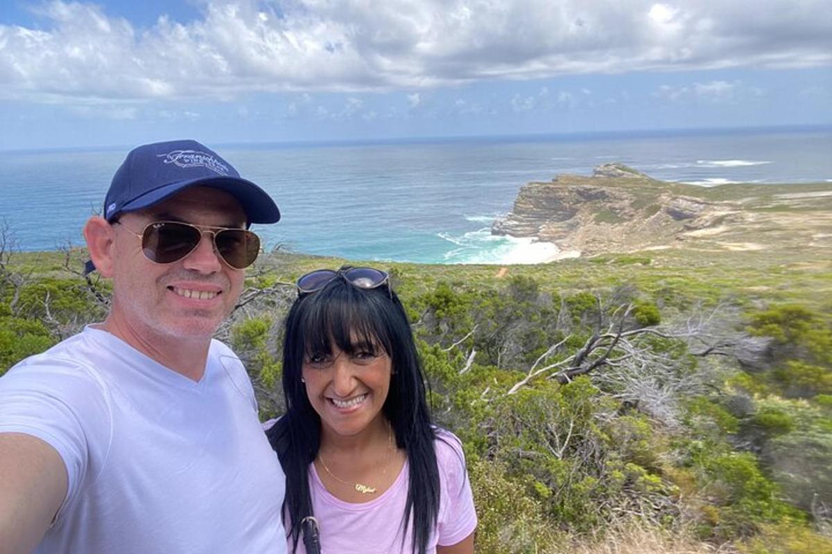 Un hombre y una mujer de pie en la cima de una playa