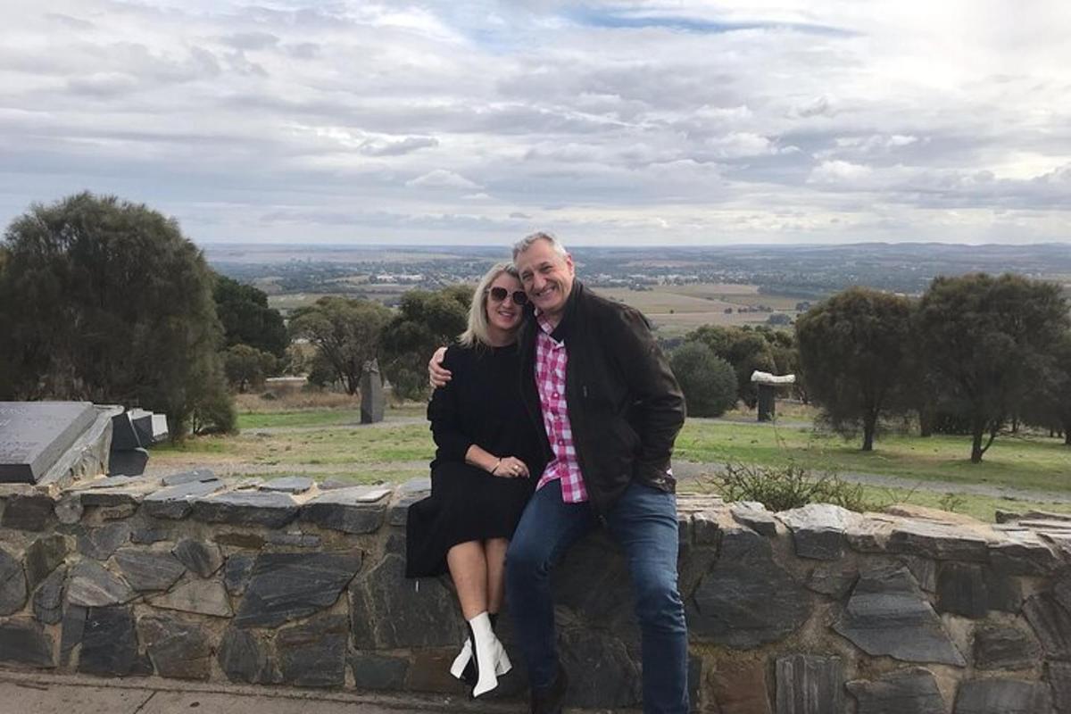 Un hombre y una mujer sentados en un muro de piedra