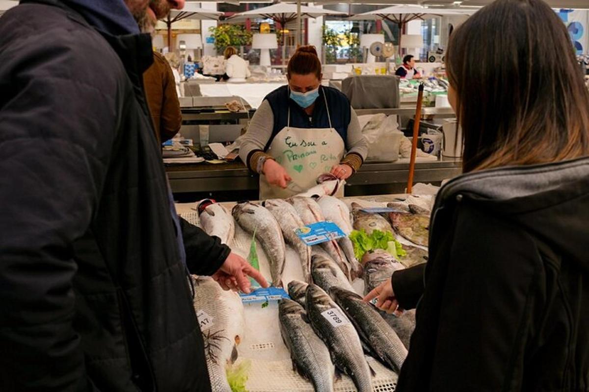 un gruppo di persone in un mercato che vende pesce