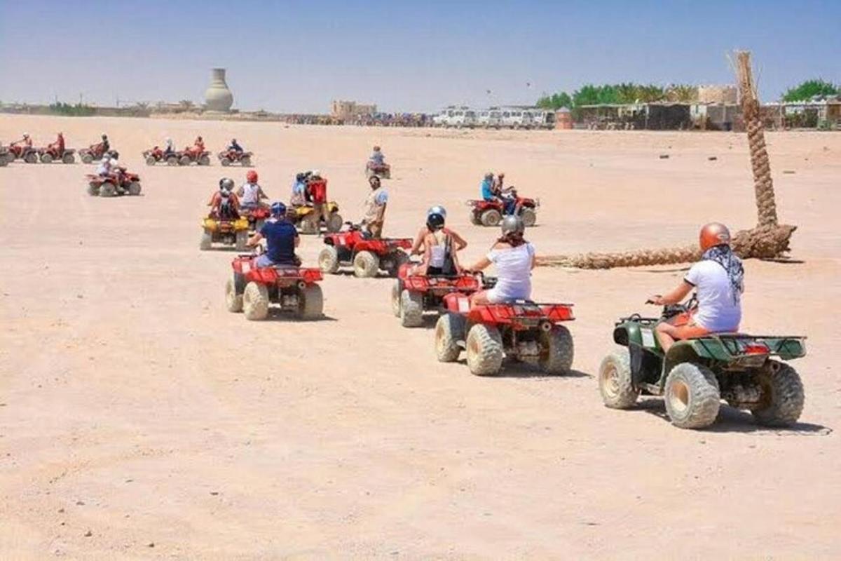 un grup de persones conduint quads a la platja