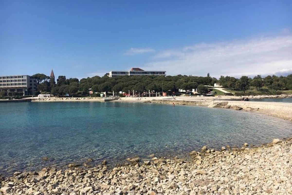 uma praia com uma costa rochosa e edifícios ao fundo
