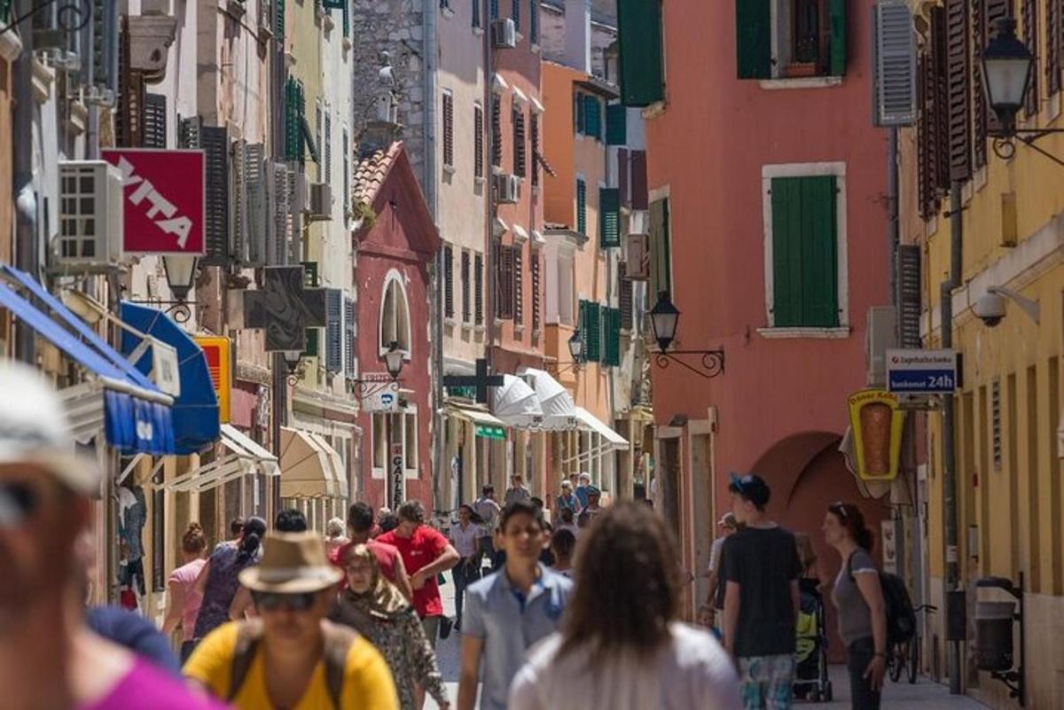 una folla di persone che camminano lungo una strada con edifici