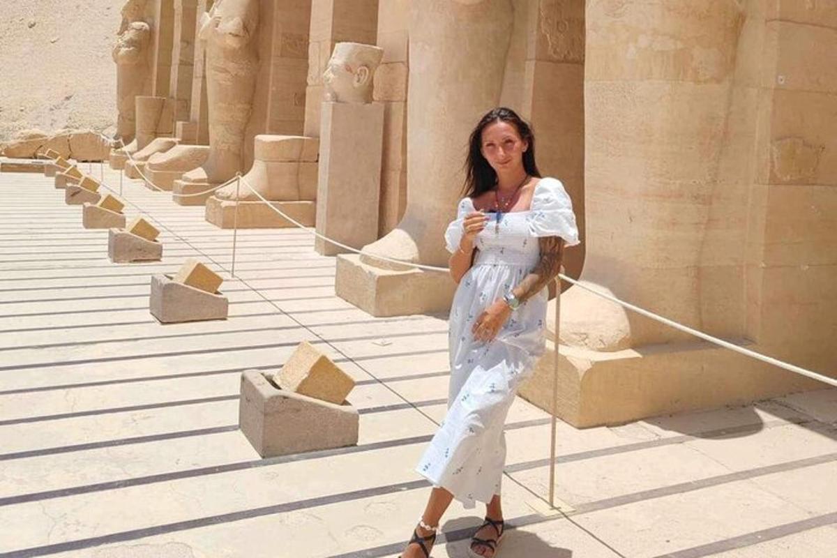 μια γυναίκα που στέκεται μπροστά σε ένα κτίριο