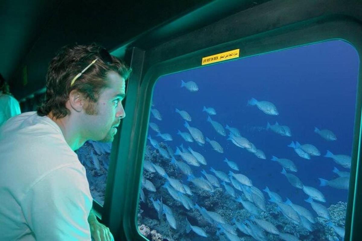 a man on a train looking at a tank of fish