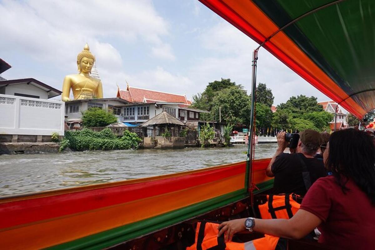 Un grupo de personas viajando en un bote en un río con una estatua.