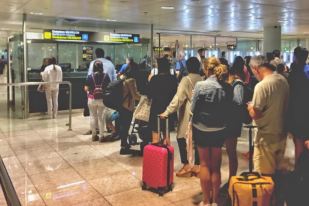 Un grupo de personas esperando su equipaje en un aeropuerto.