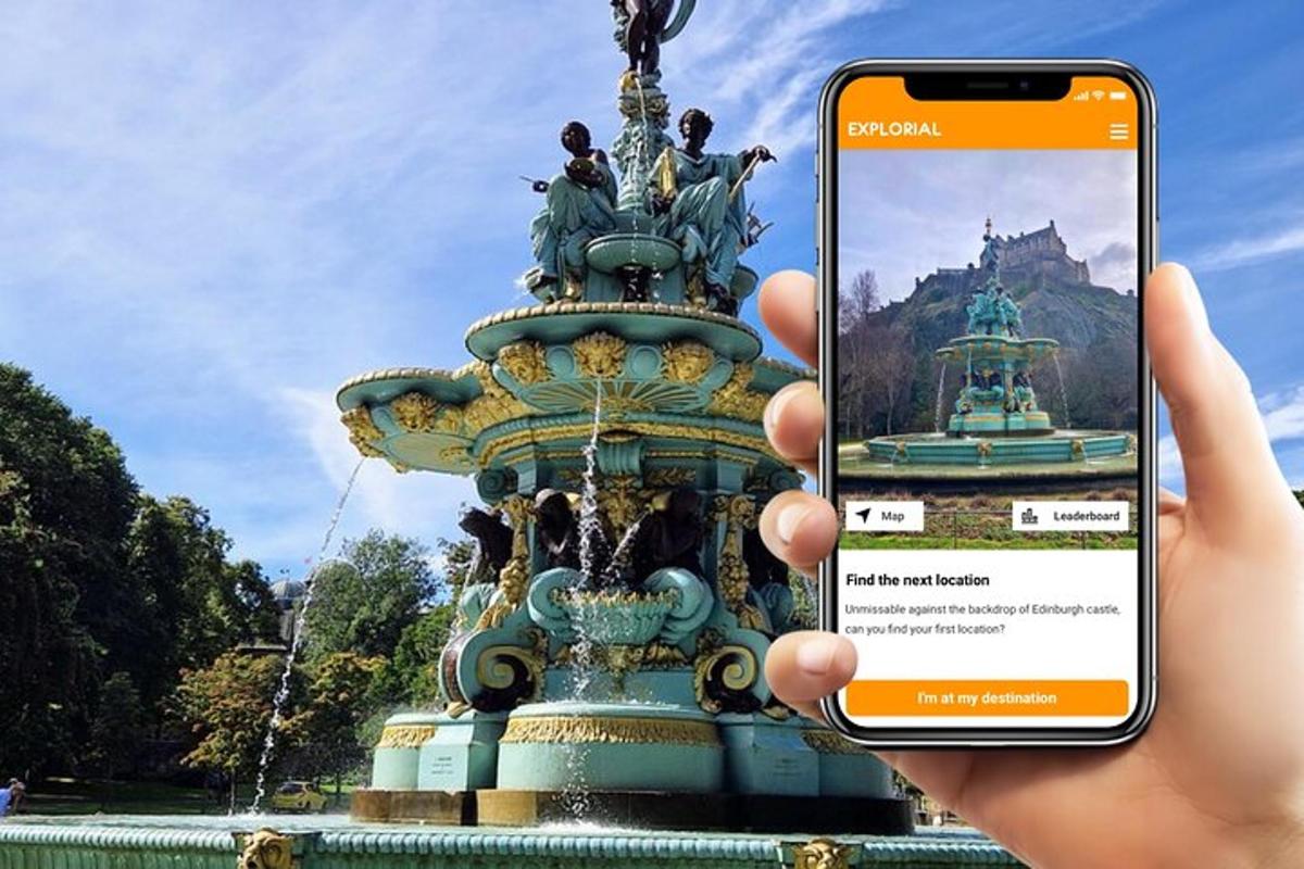 osoba držící mobilní telefon před fontánou
