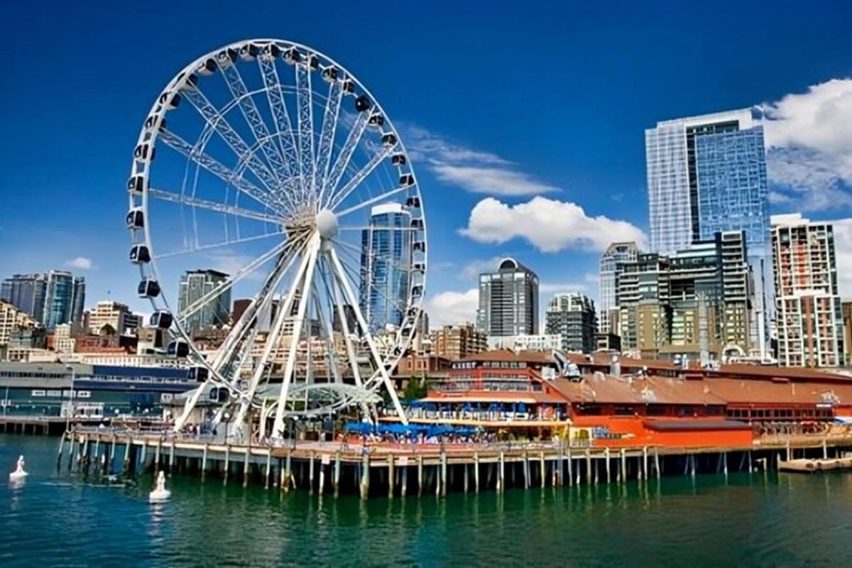 a ferris wheel sitting in the water near a city