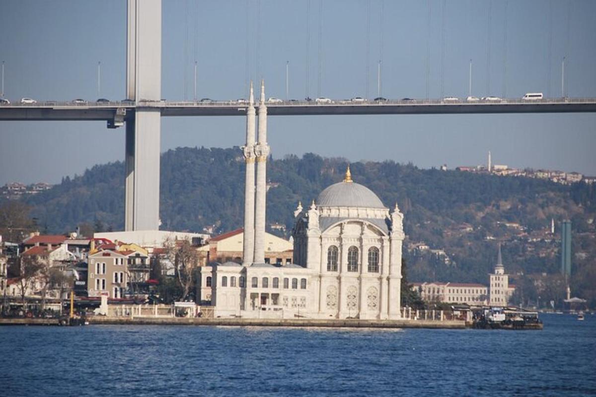 Un gran edificio blanco sobre el agua junto a un puente.