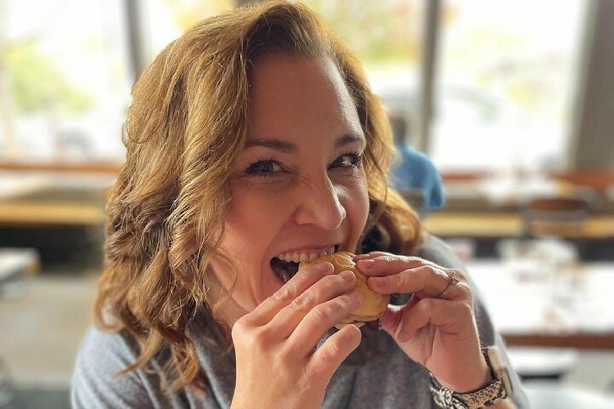 a woman is eating a sandwich with her hands