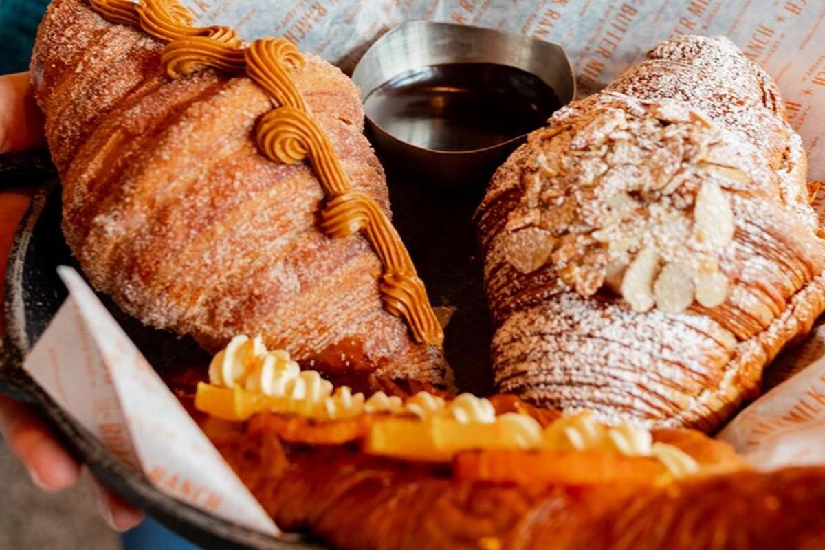 a person holding a basket of pastries and waffles