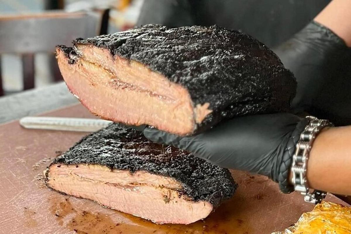 a person in black gloves holding a piece of meat