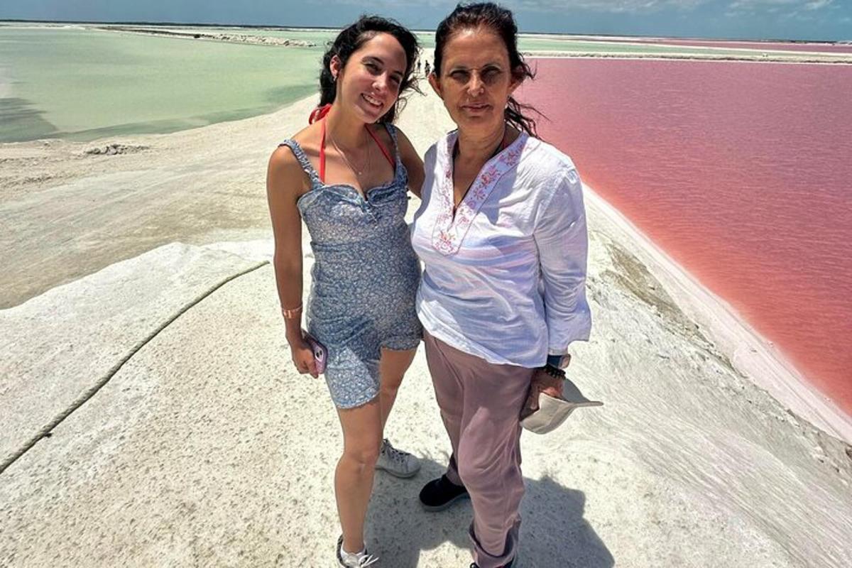 two women standing next to each other on the beach
