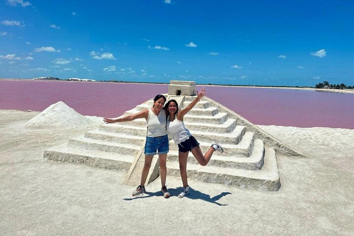 two people standing on the steps of a body of water