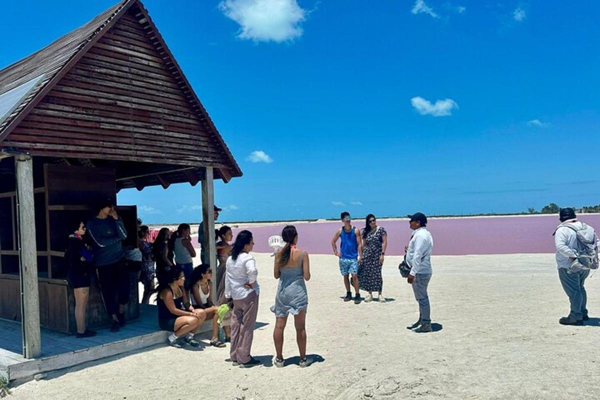 a group of people standing around a bar on the beach