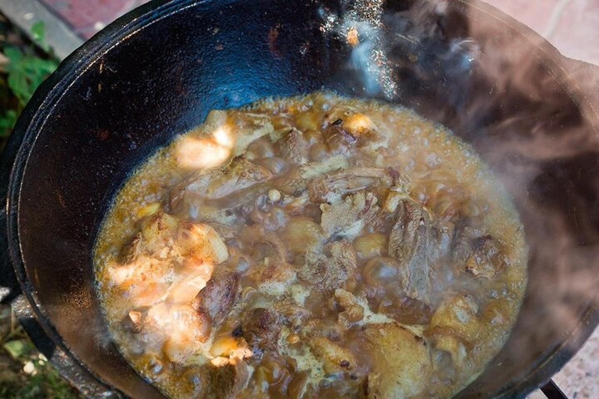 a pot of soup with meat and mushrooms in it
