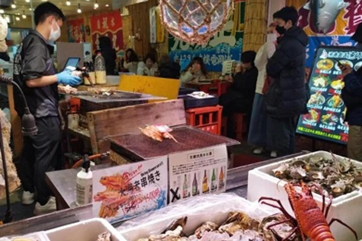 a group of people standing in a market with food