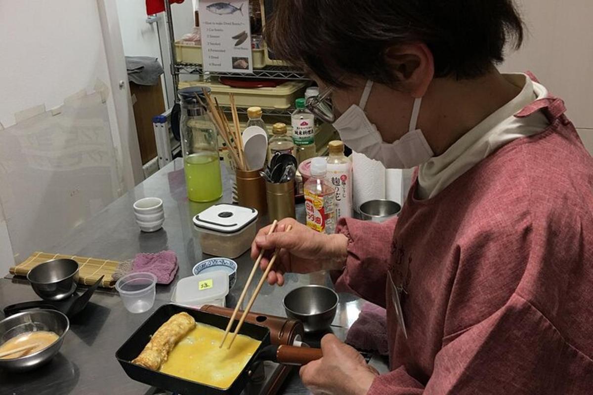 a woman cooking food in a pan on a counter