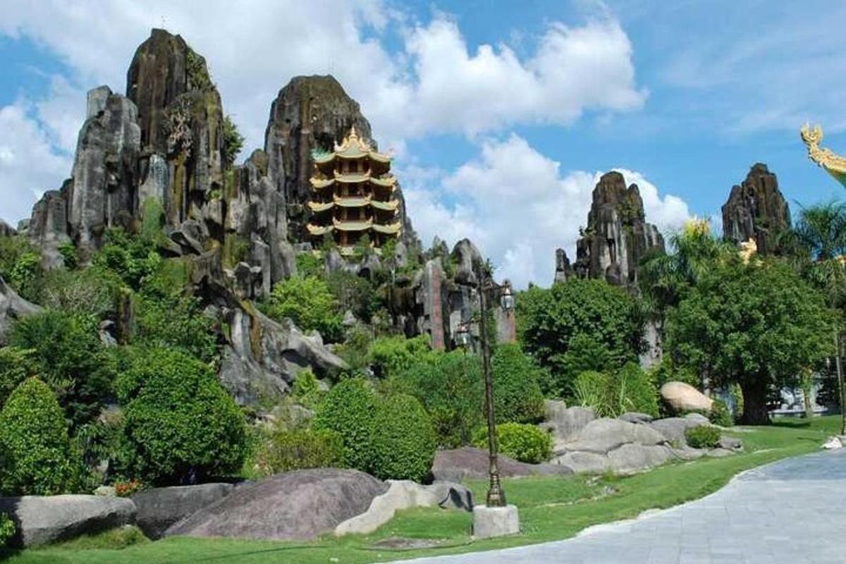 Un parque con rocas y una pagoda al fondo.