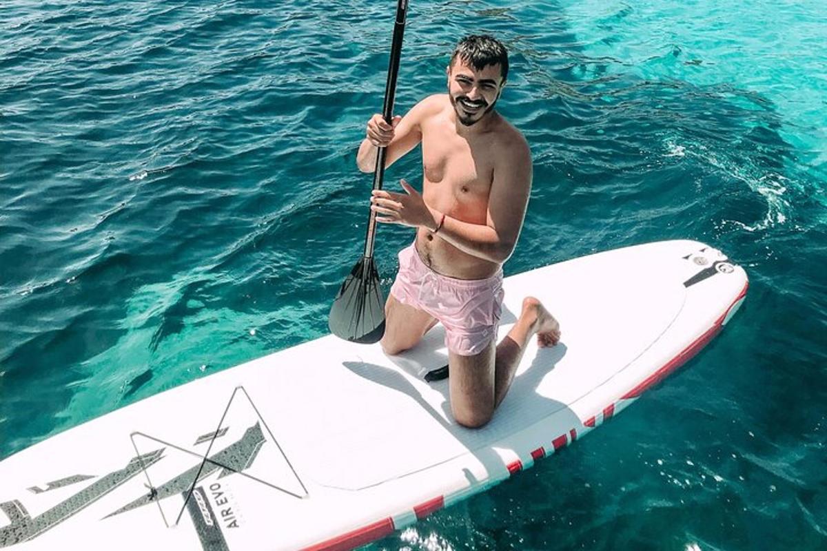 a man holding a paddle on a surfboard in the water