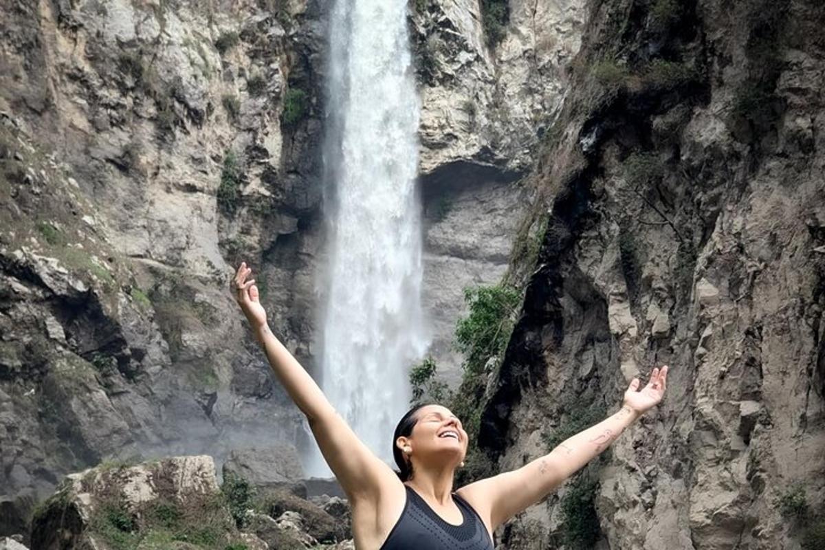 una donna in piedi davanti a una cascata