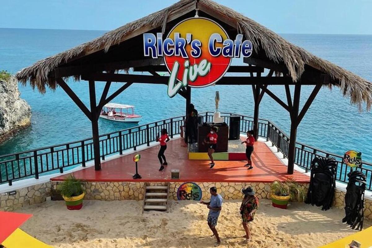 a group of people playing volleyball in a pavilion on the beach