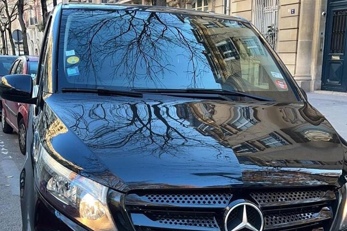 ein schwarzes Auto mit der Spiegelung eines Baumes auf der Vorderseite