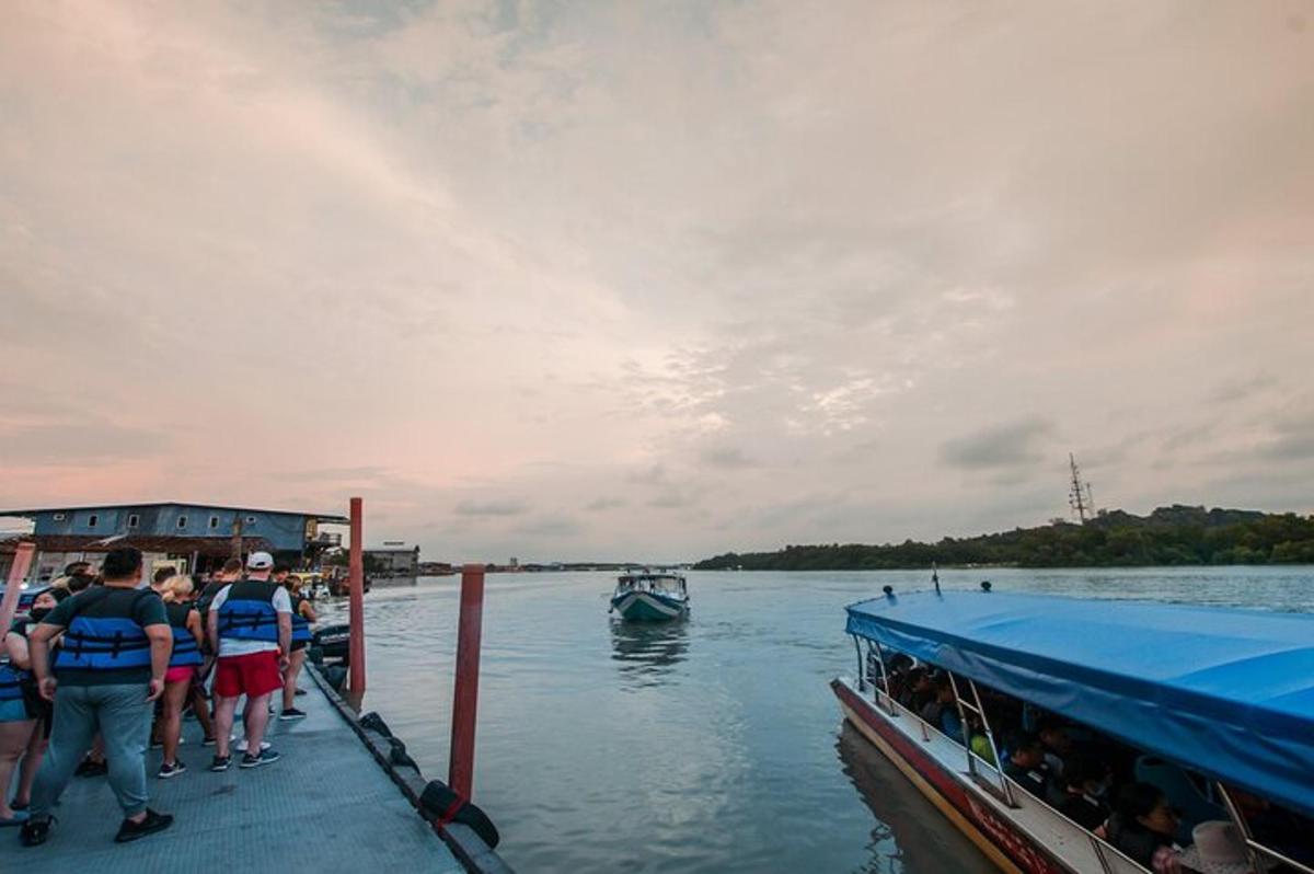 a group of people boarding a boat on the water