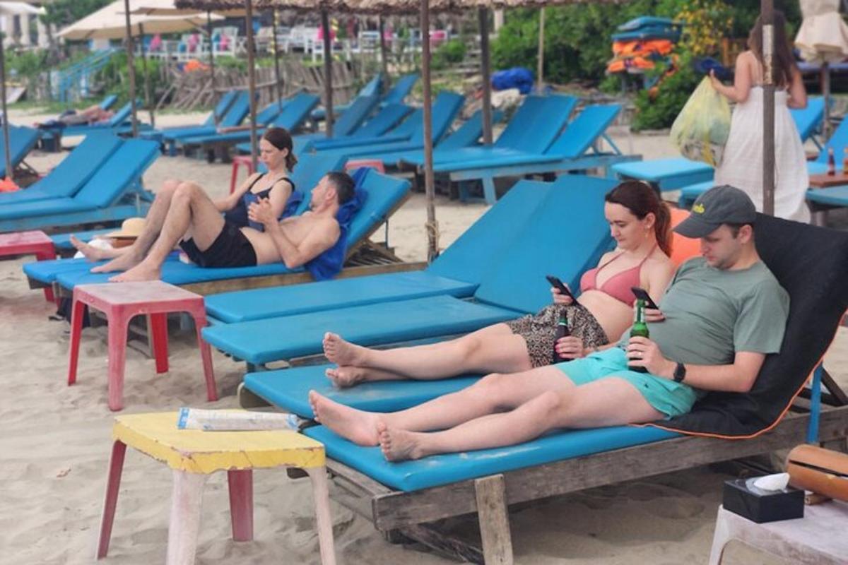 um grupo de pessoas sentadas em cadeiras na praia