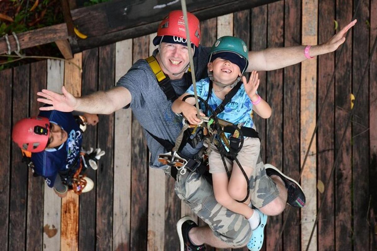 seorang lelaki memegang kanak-kanak pada zip line