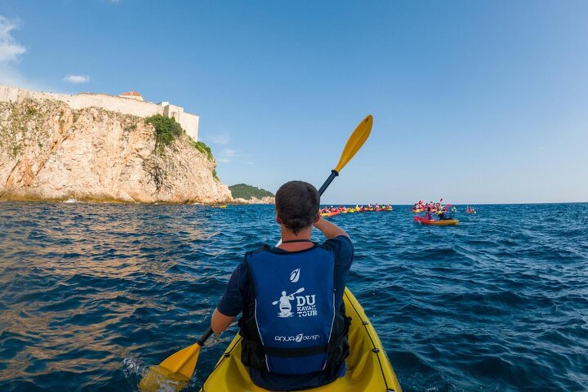 Un hombre en un kayak amarillo en el agua.