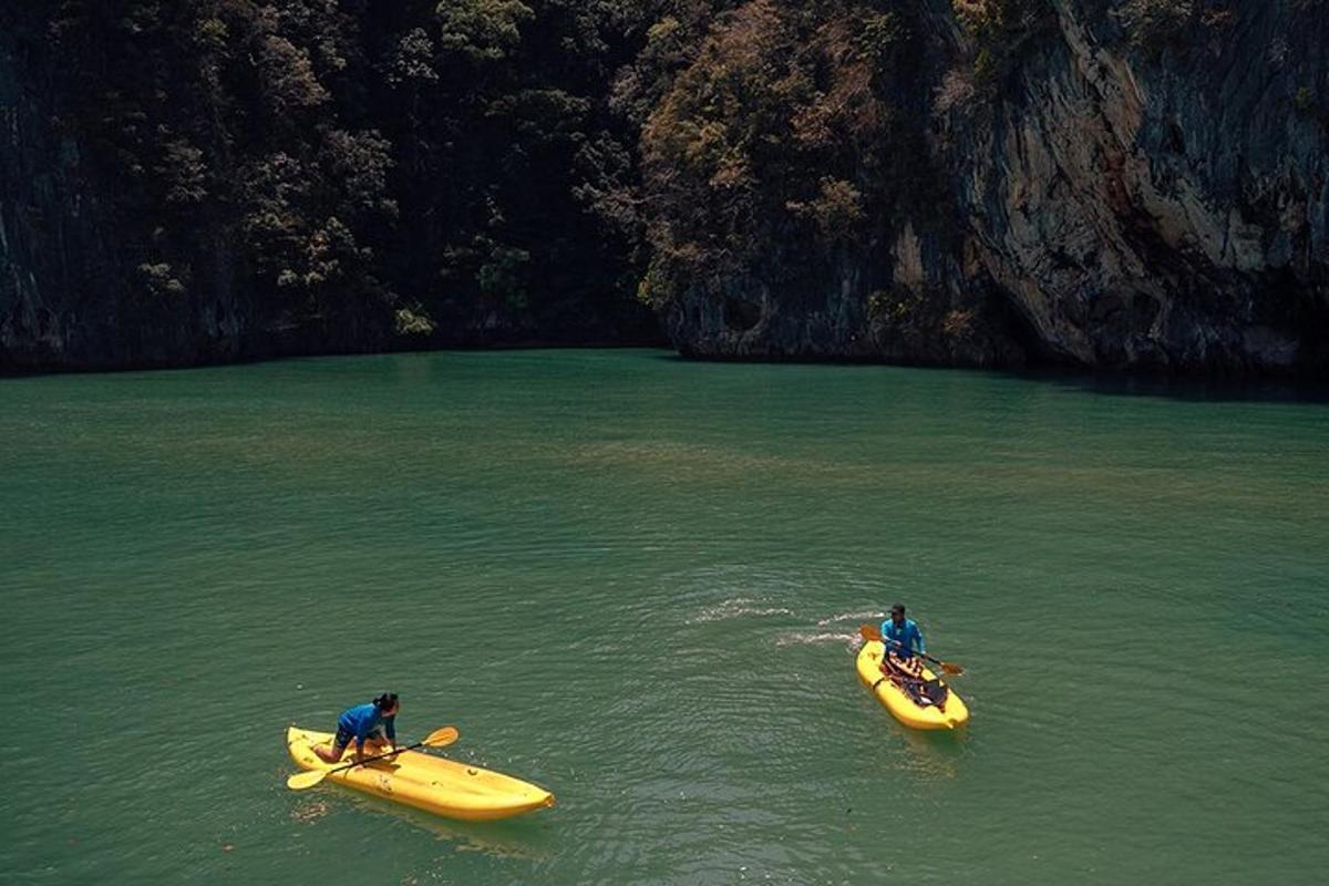 คนสองคนในเรือคายัคสีเหลืองในน้ำใกล้ถ้ำ