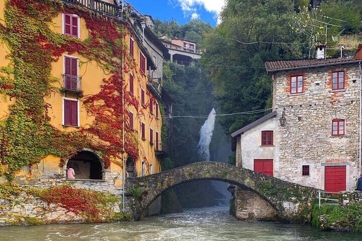 a bridge over a river with buildings and a waterfall