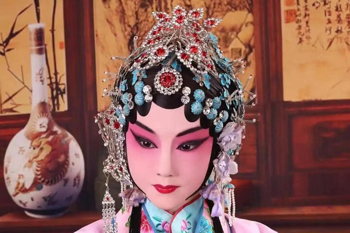 Una muñeca con una tiara en la cabeza junto a un jarrón.