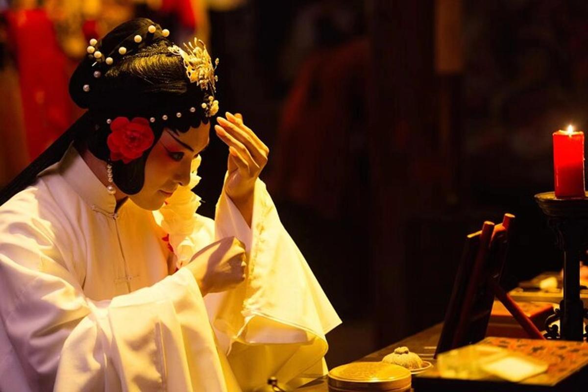 Una mujer con traje de geisha sentada en una mesa.