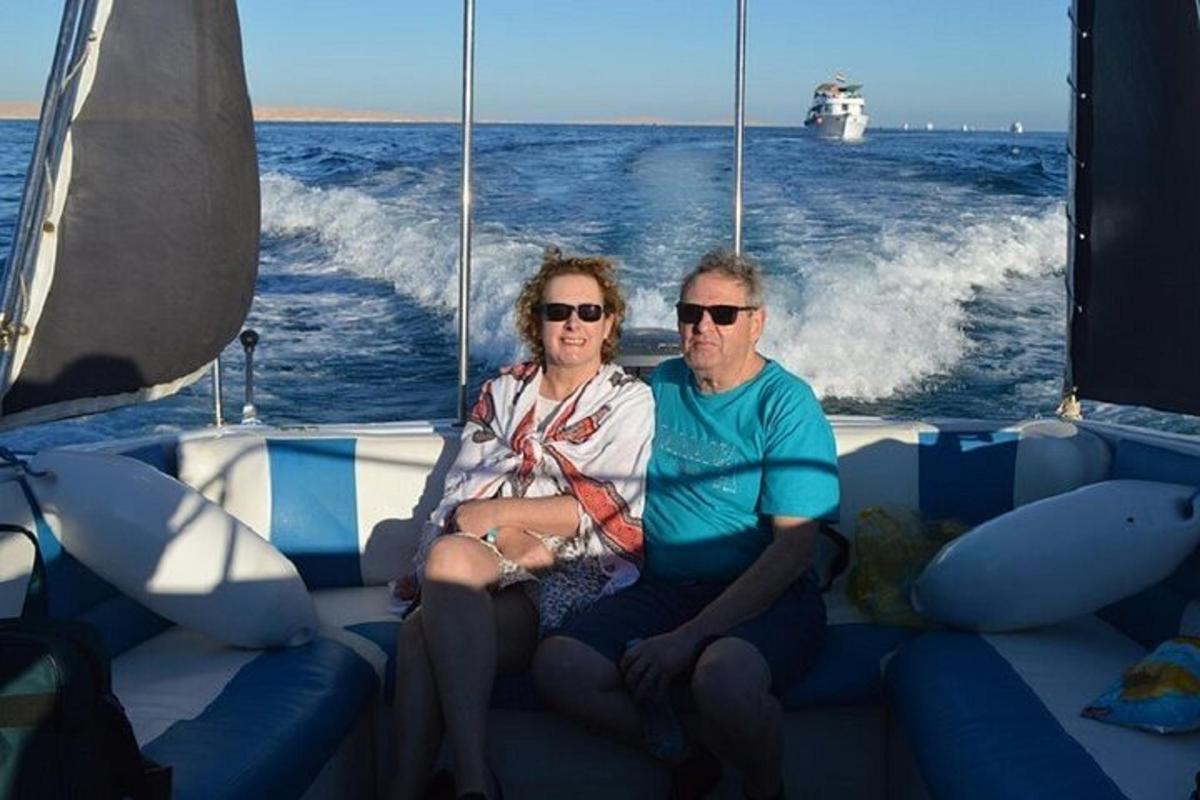 un bărbat și o femeie stând pe o barcă în ocean