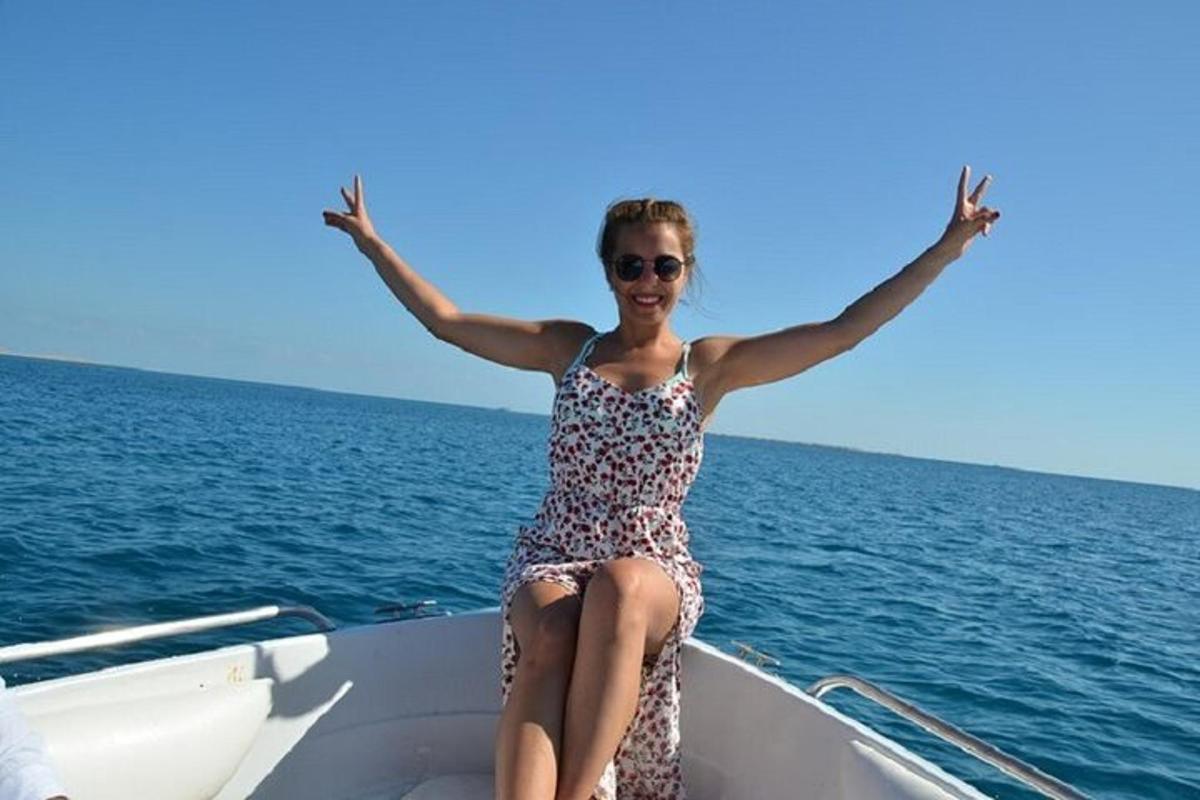 o femeie într-o rochie stând pe o barcă în ocean