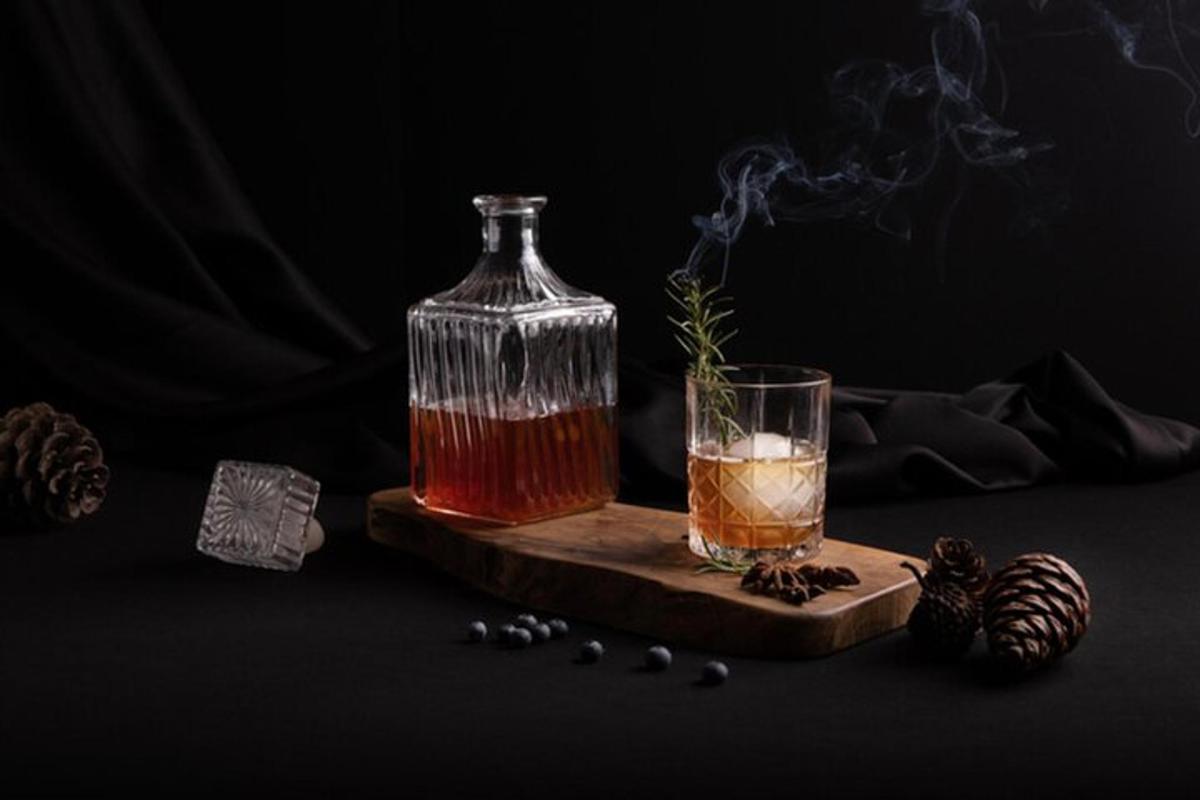 a drink in a bottle on a cutting board with smoke