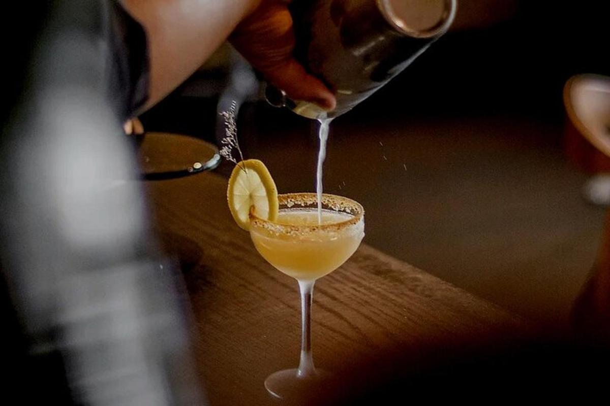 a person is pouring a drink into a glass