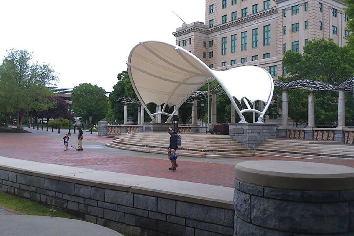 a group of people standing around a sculpture in front of a building