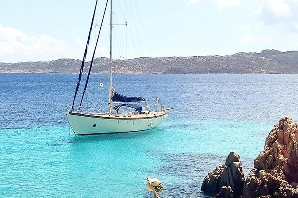 Un velero en el agua junto a unas rocas