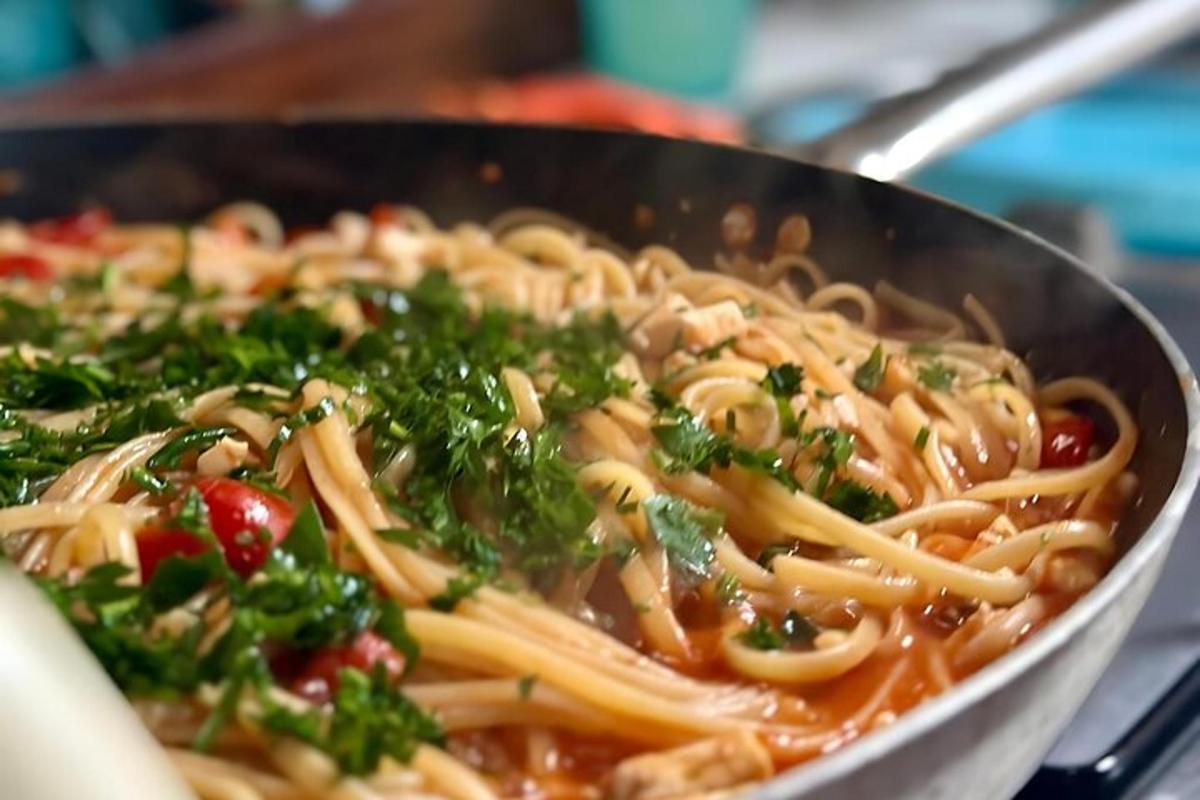 isang kawali ng pasta na may perehil at mga kamatis