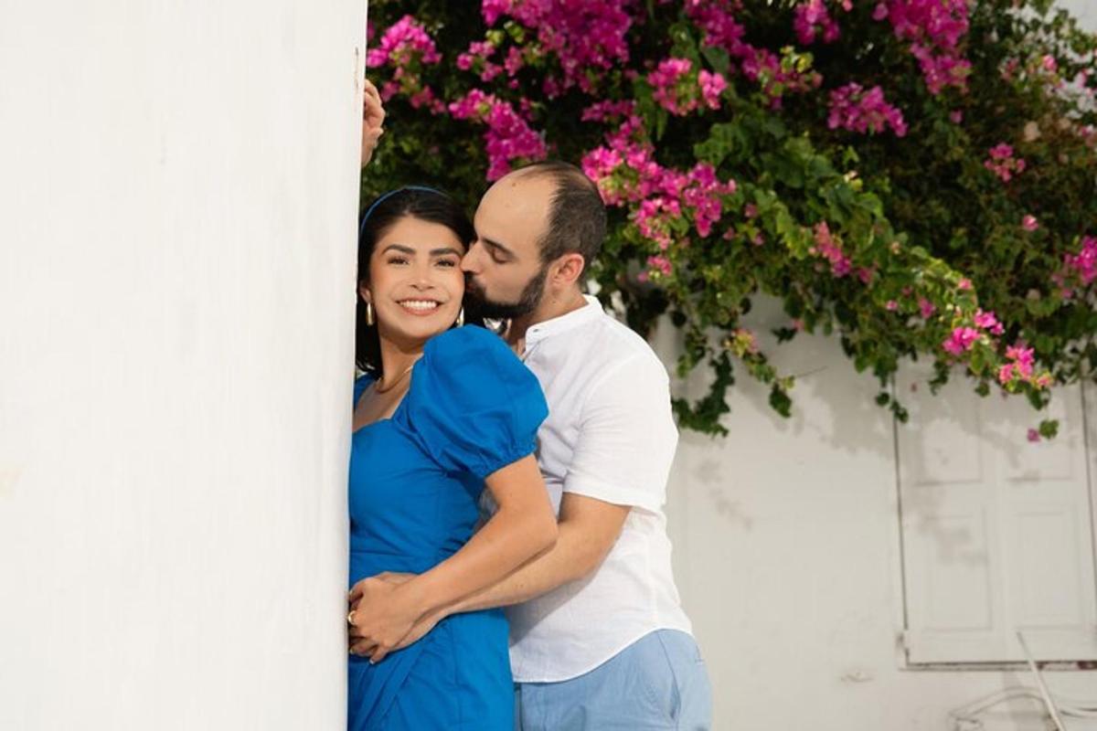 Un hombre y una mujer de pie junto a una pared con flores.