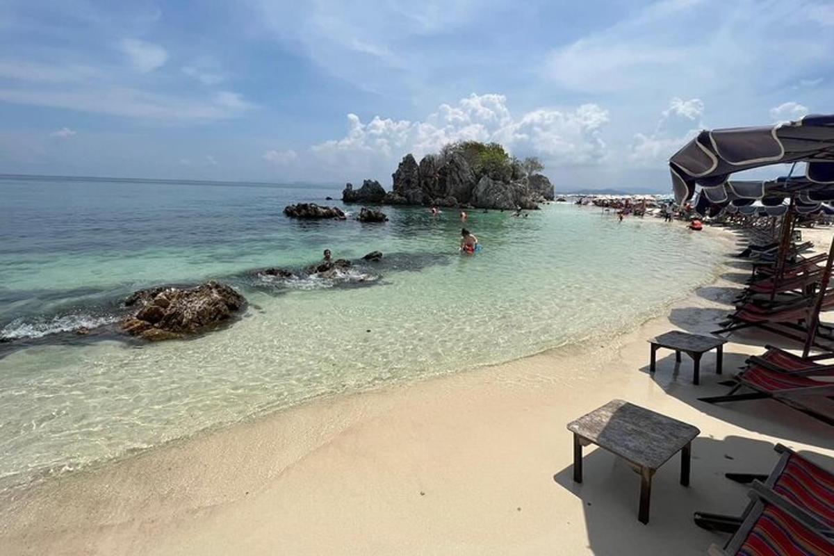 una spiaggia con sedie e persone in acqua
