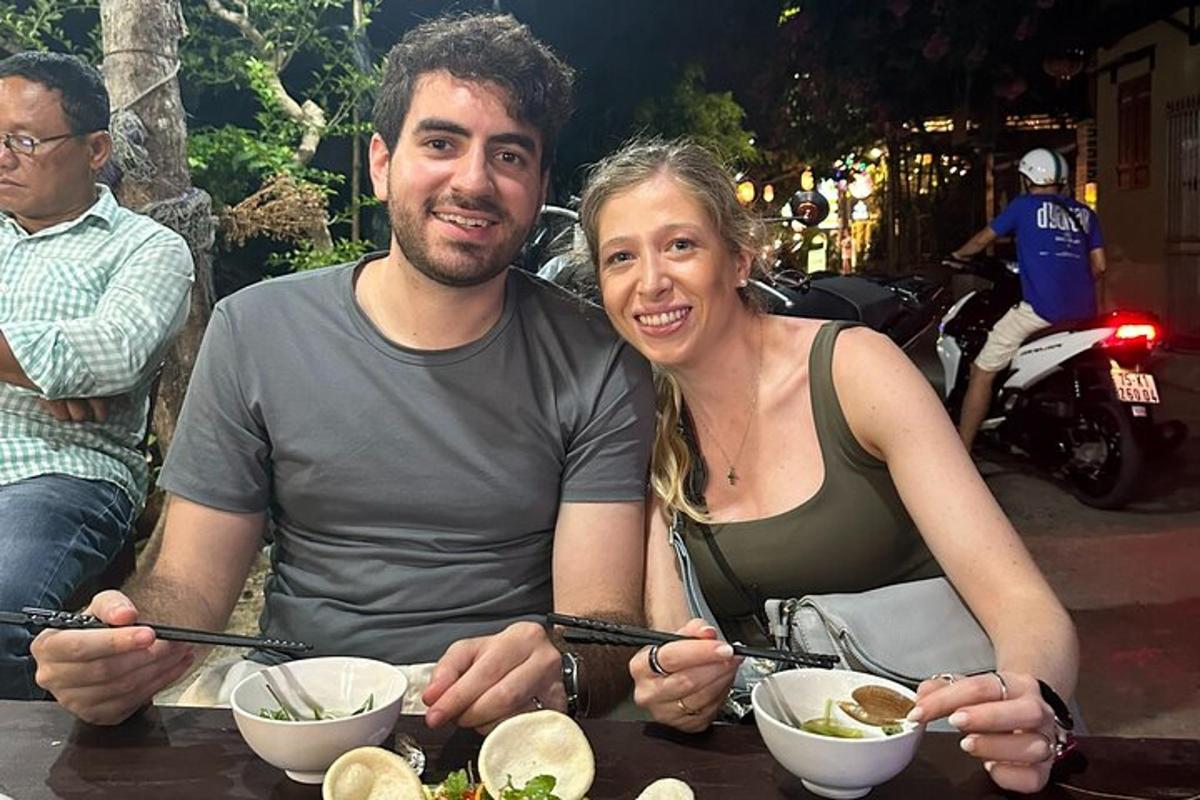 un uomo e una donna seduti a un tavolo con ciotole di cibo