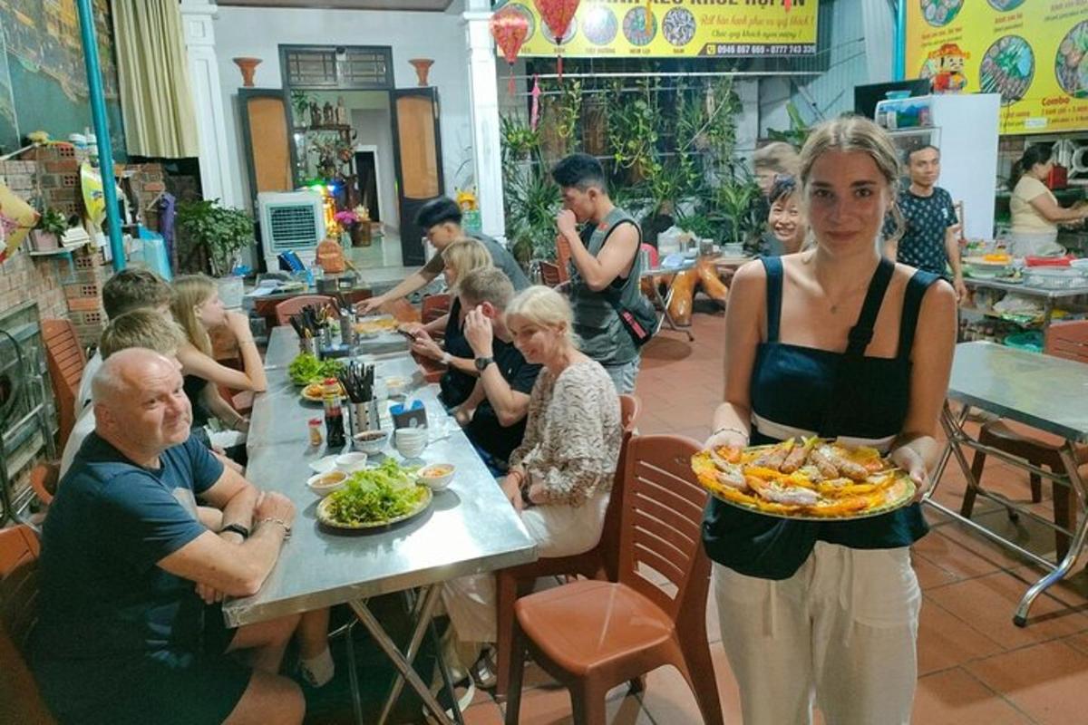 uma mulher segurando um prato de comida em um restaurante