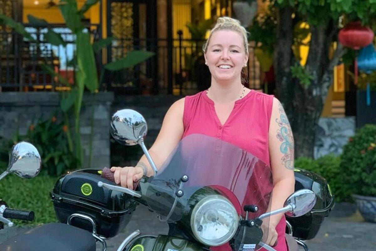 una donna in abito seduta su una motocicletta