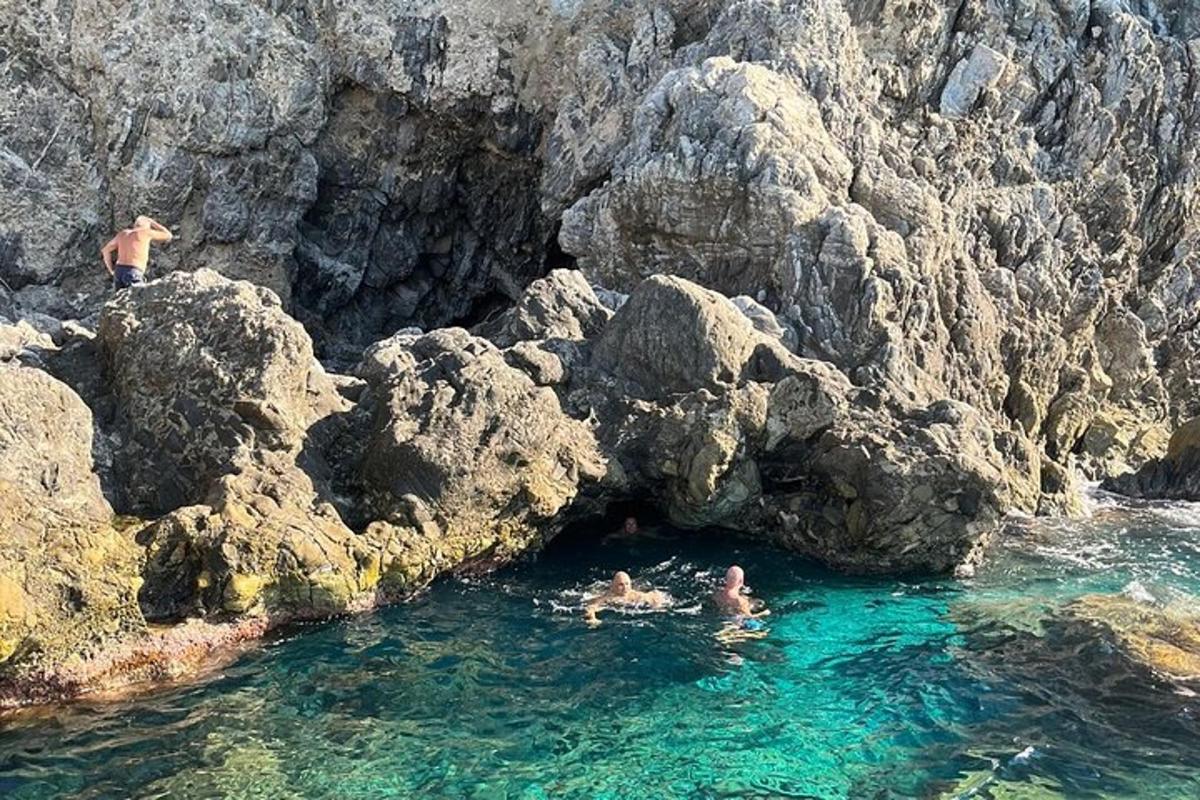 zwei Menschen schwimmen im Wasser in der Nähe einiger Felsen