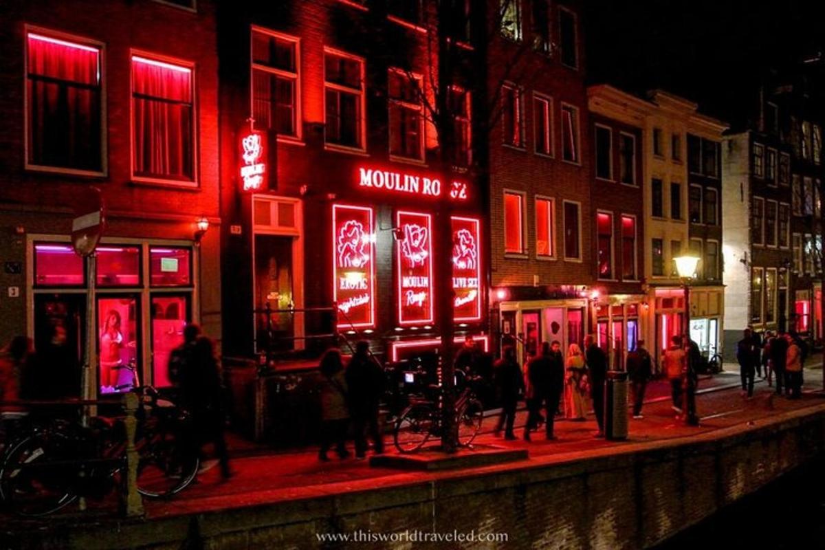 a group of people walking down a street at night